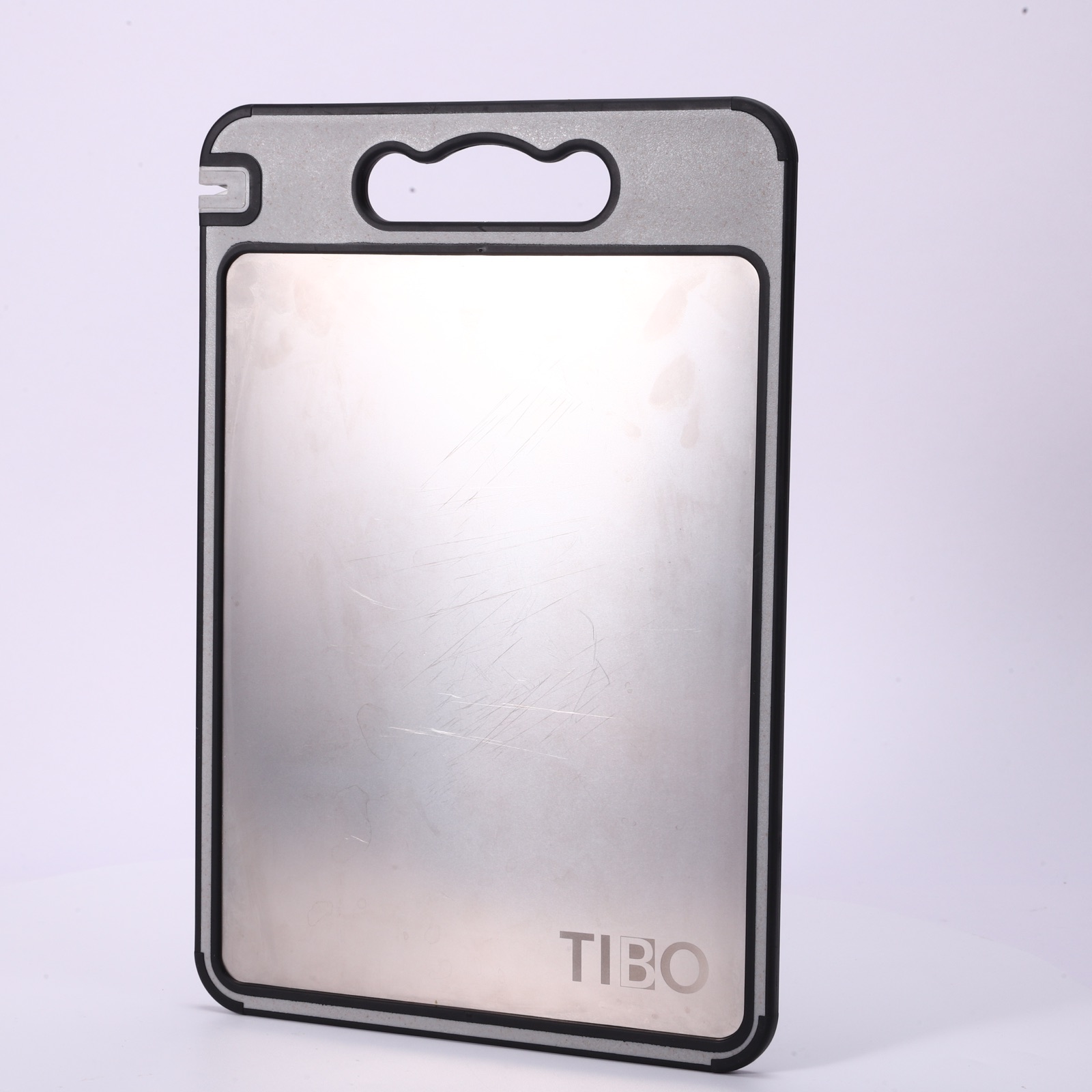 TIBO titanium cutting board shown on a dark studio background